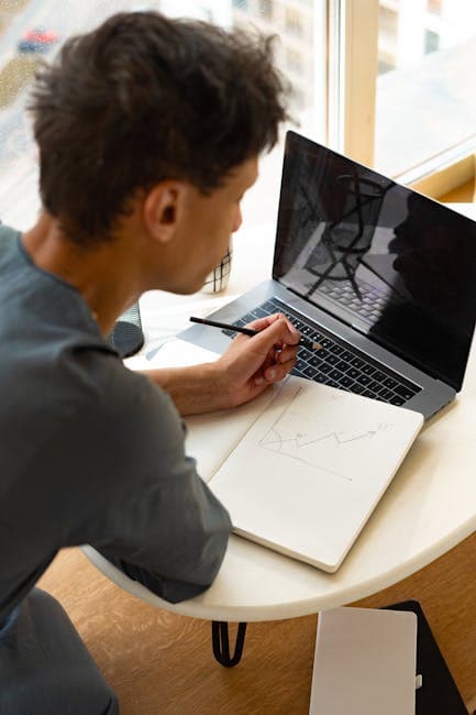 Student attentively analyzing graphs and data at a laptop indoors, illustrating modern learning.