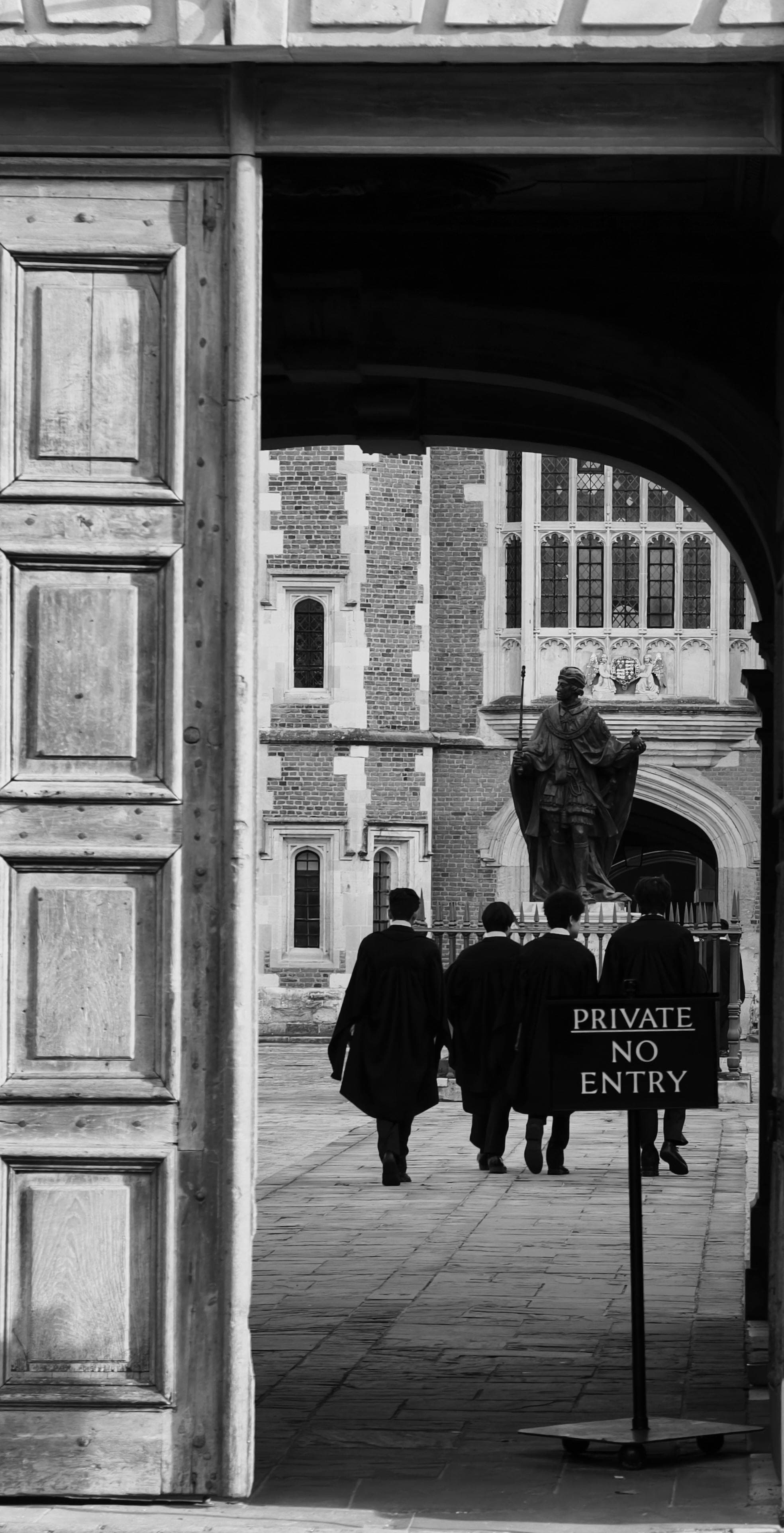 Black and white image of people in robes near a historic court building entrance.