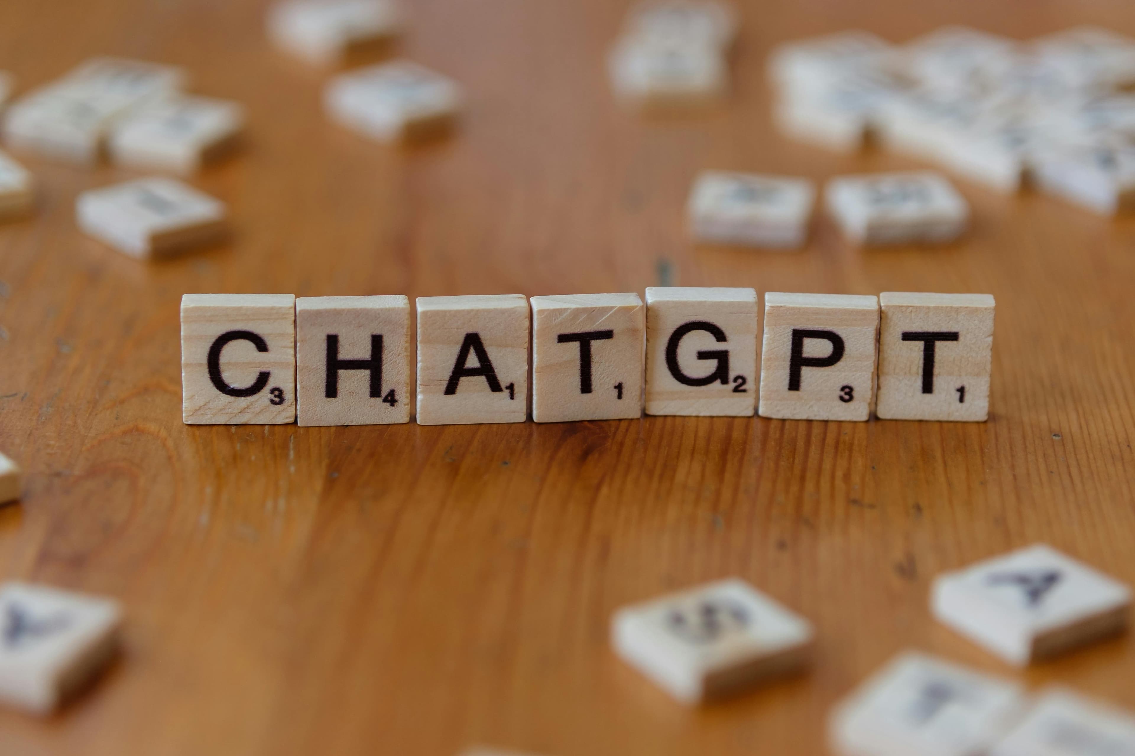 حروف اسکرابل که "CHATGPT" را روی سطح چوبی می‌سازند، با تأکید بر مدل‌های زبانی هوش مصنوعی.