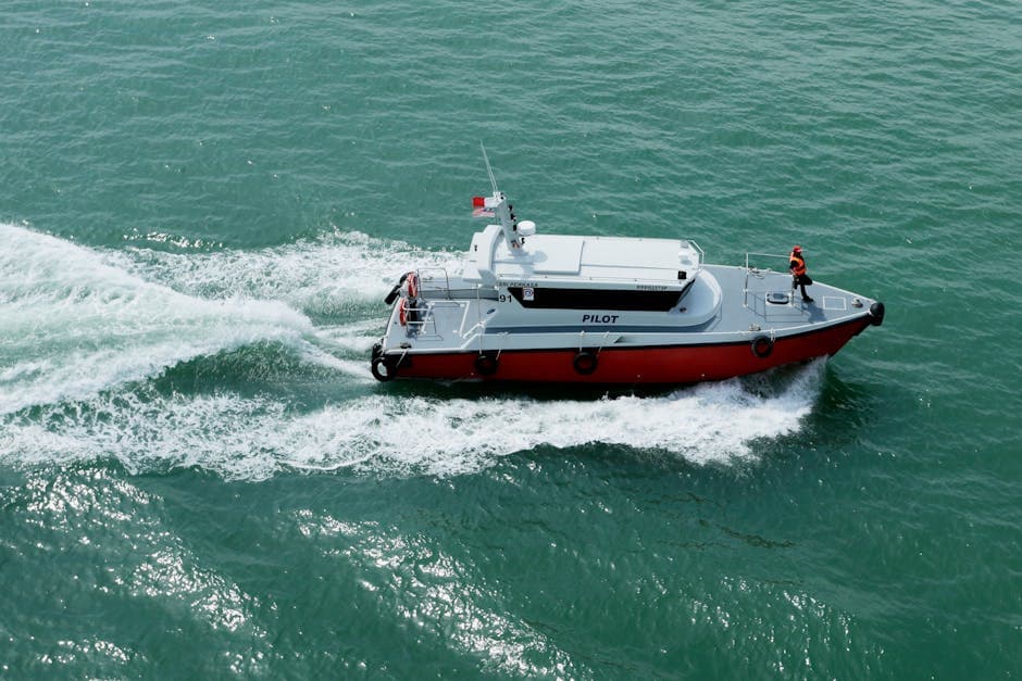 Pilot boat sailing through open sea, creating waves in its wake.