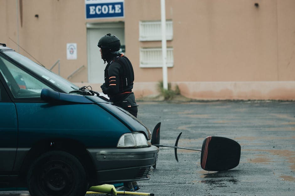 Man in safety gear near a vehicle outside a school in Agde, France.