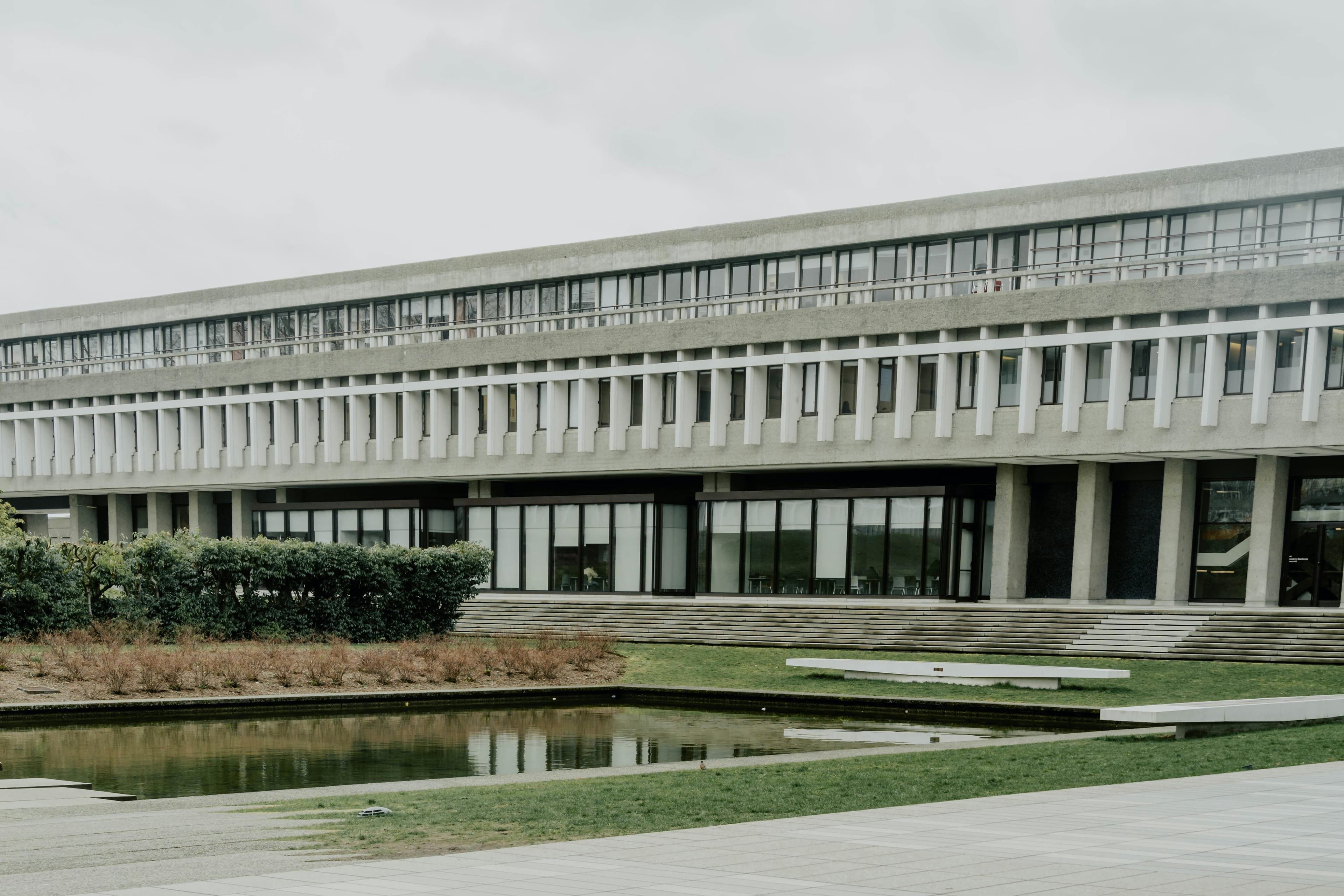 منظر للهندسة المعمارية الوحشية لجامعة سايمون فريزر مع بركة عاكسة في بورنبي، كندا.