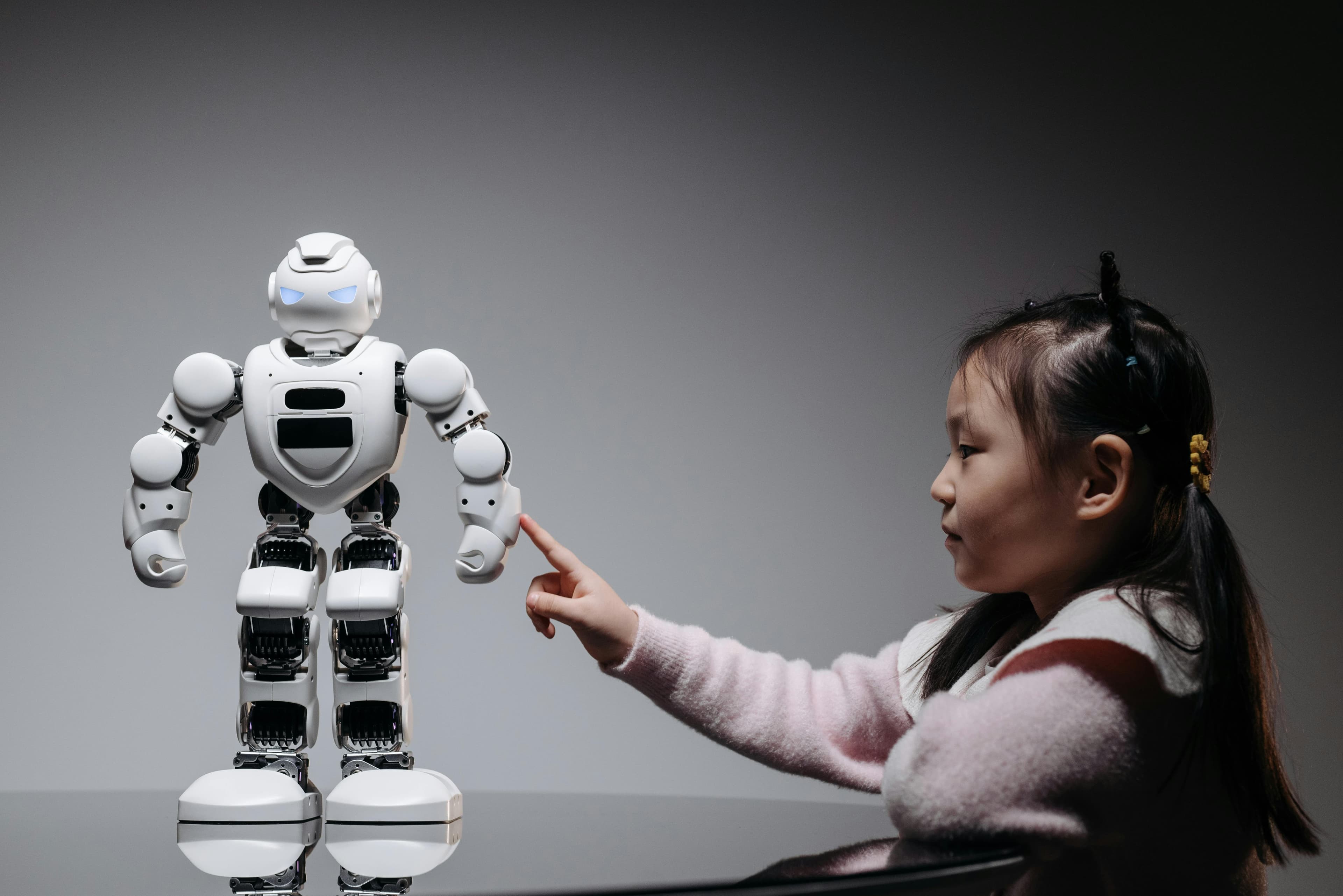Merak ve yeniliği vurgulayan, robotik bir oyuncakla etkileşime giren genç bir kız.