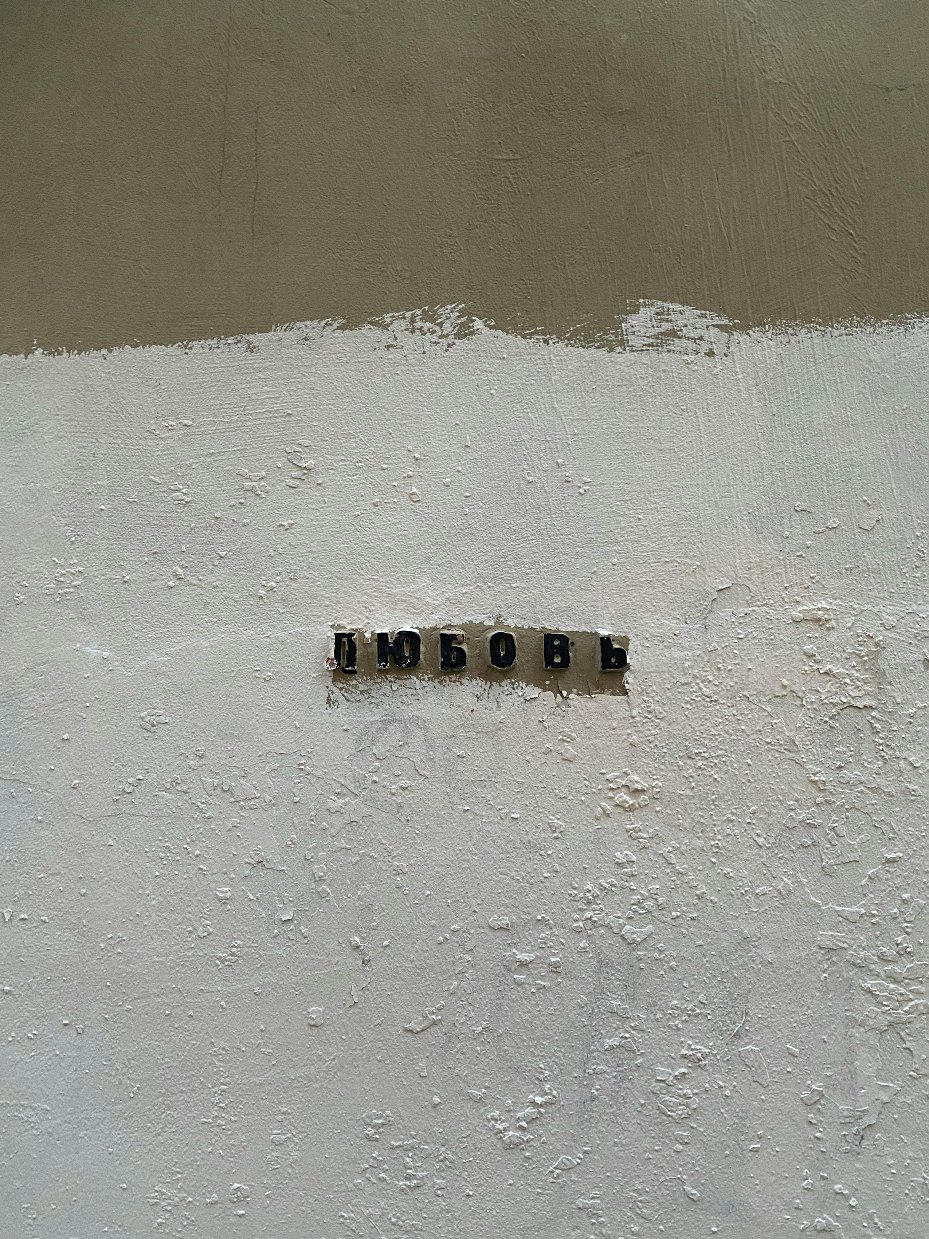 Close-up of a rough wall with the word 'Love' in Cyrillic letters.