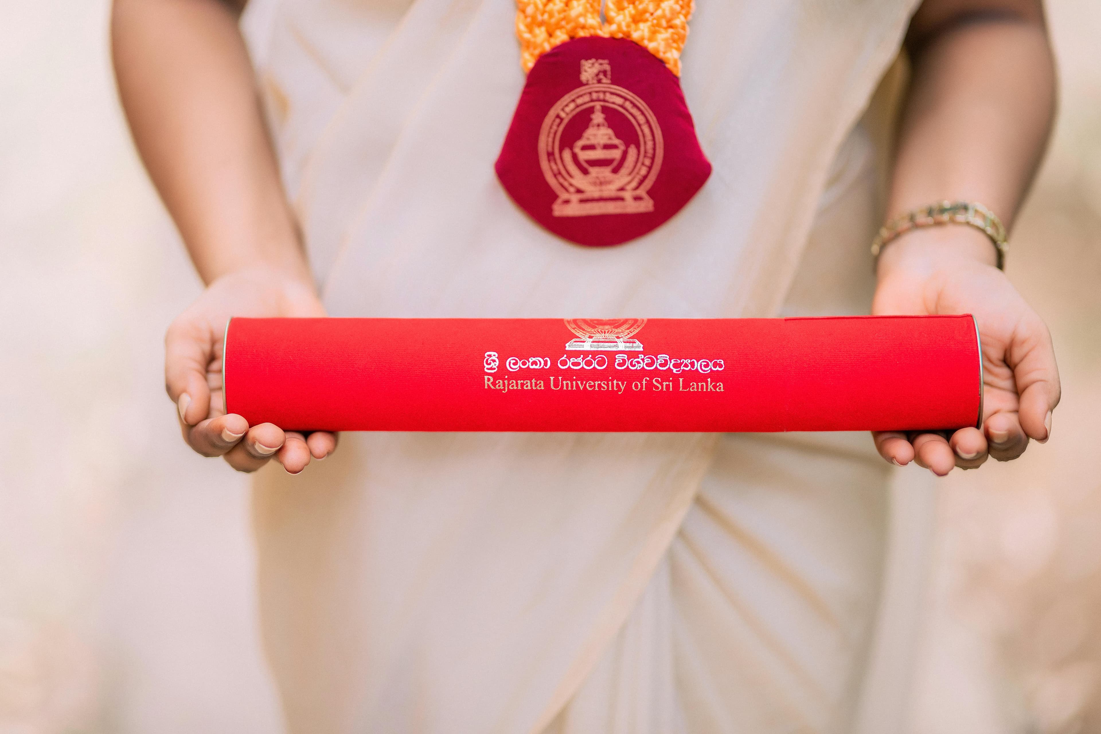 A graduate proudly holds a diploma from Rajarata University of Sri Lanka.