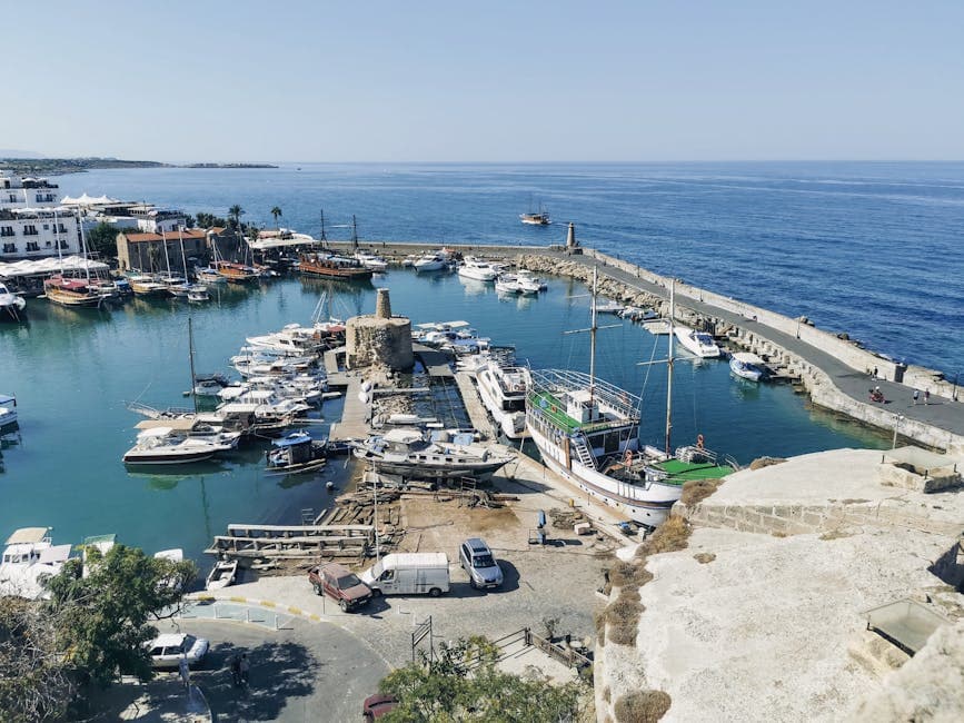 Aerial view of Kyrenia Harbor with boats and sea under clear blue skies.