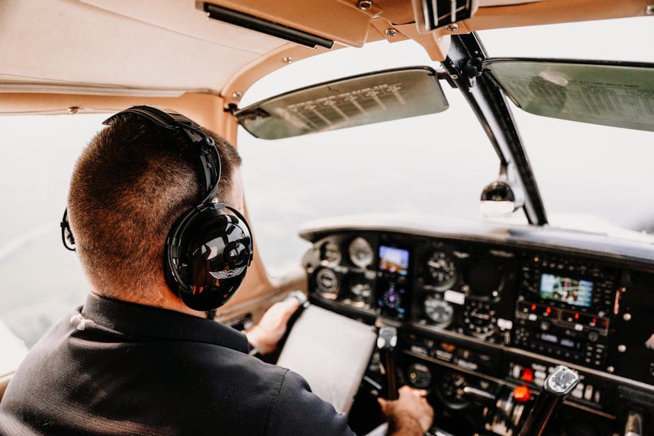 A pilot flying an airplane, focusing on the cockpit instruments and wearing a headset.