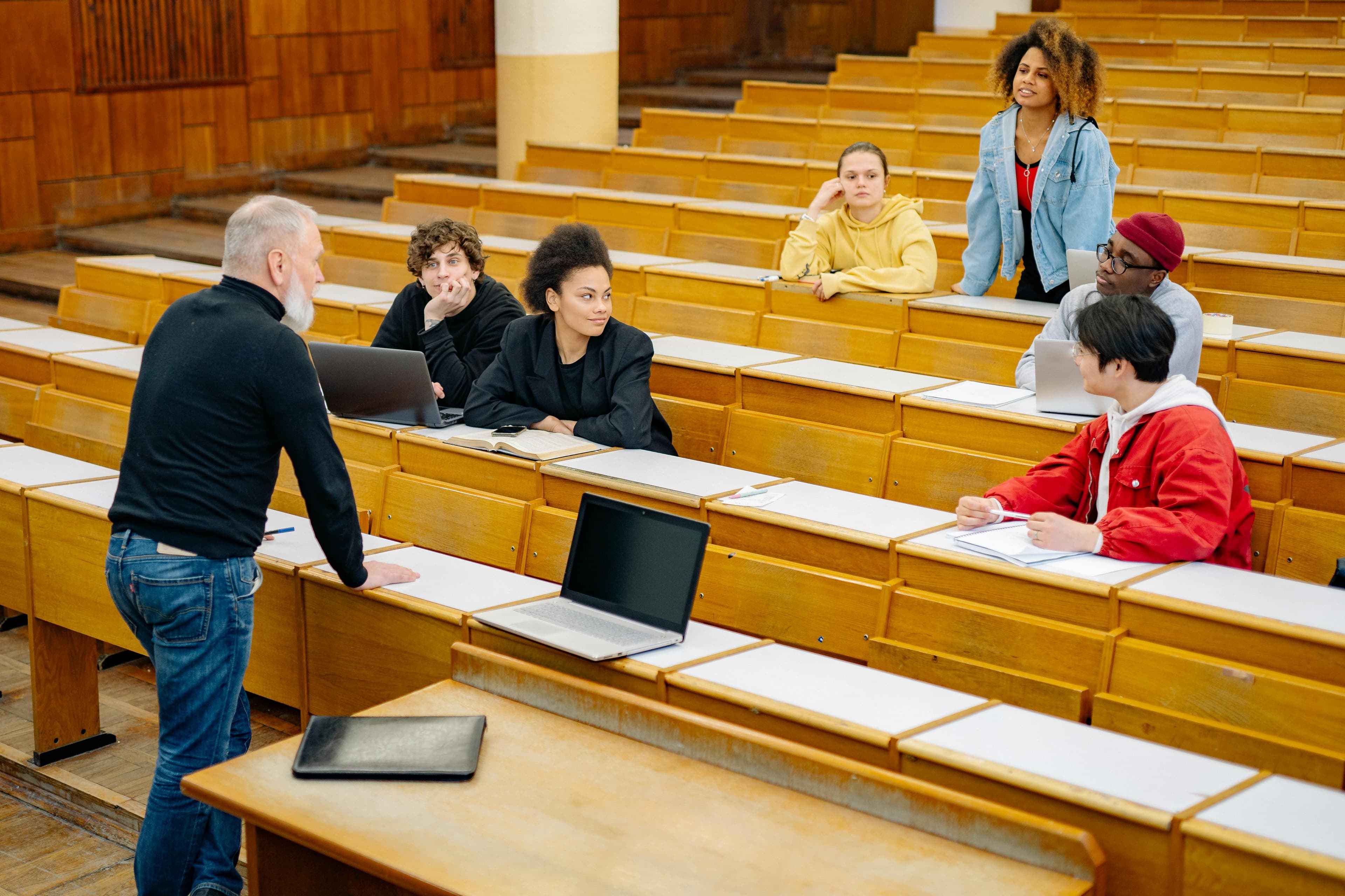 Students actively listening and engaging in a university lecture setting, showcasing diversity.