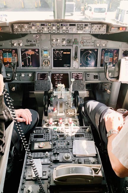 View of a commercial airplane cockpit with two pilots handling the controls, ready for flight.