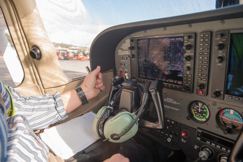 Close-up of a pilot navigating aircraft controls with modern avionics in a small plane cockpit.