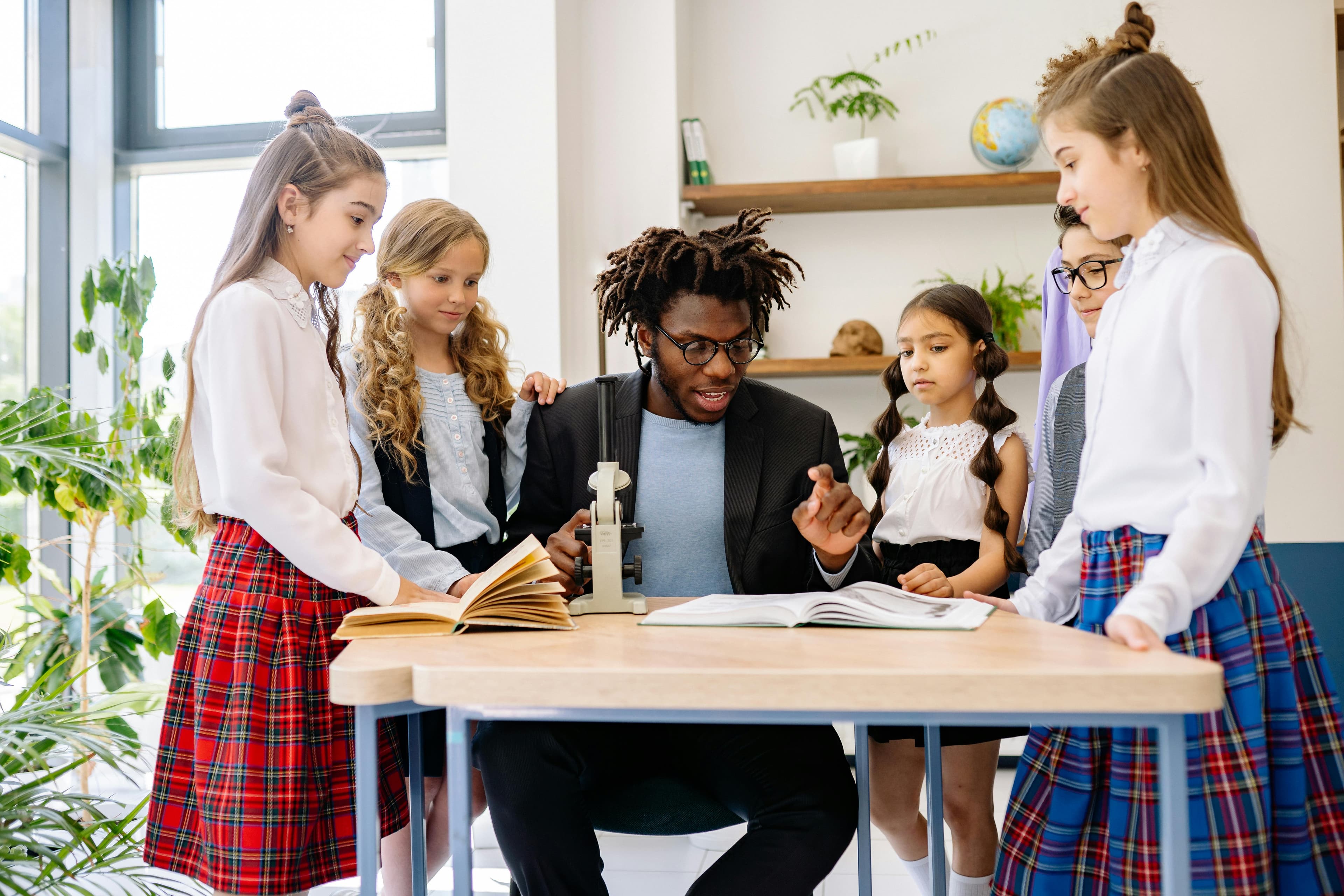 Groupe d'adolescents divers posant avec leur enseignant dans une salle de classe moderne.