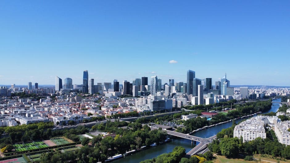 Stunning aerial view of Paris' La Défense skyline with clear blue skies.