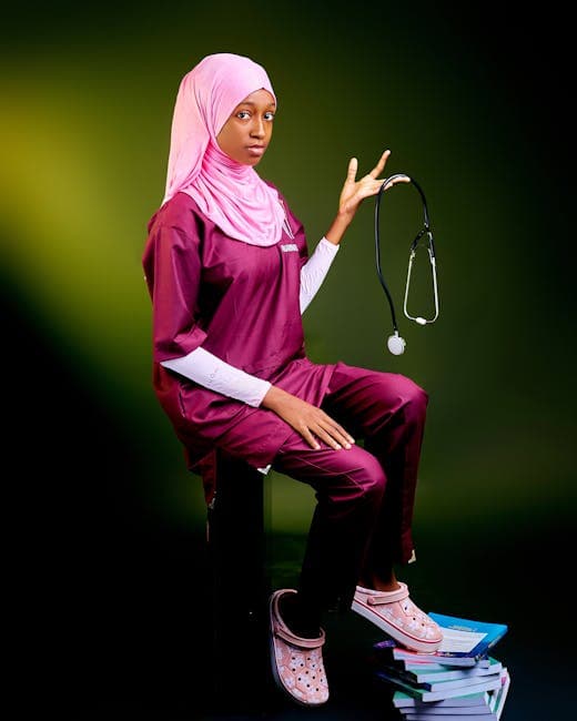 Young female medical student in scrubs and hijab holding a stethoscope, symbolizing diversity in healthcare.