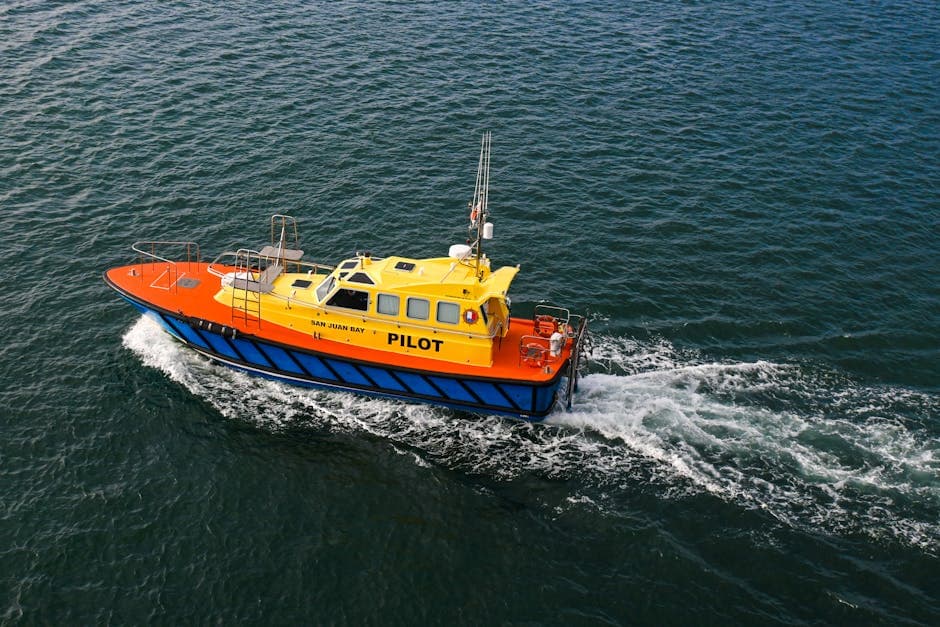 A colorful pilot boat cruising through open waters with visible waves.