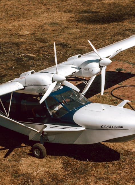 A high angle view of a sleek SK-14 Orion light aircraft parked on grassy terrain.
